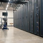 Gabinetes metálicos com servidores, equipamentos de rede e cabos em um data center moderno