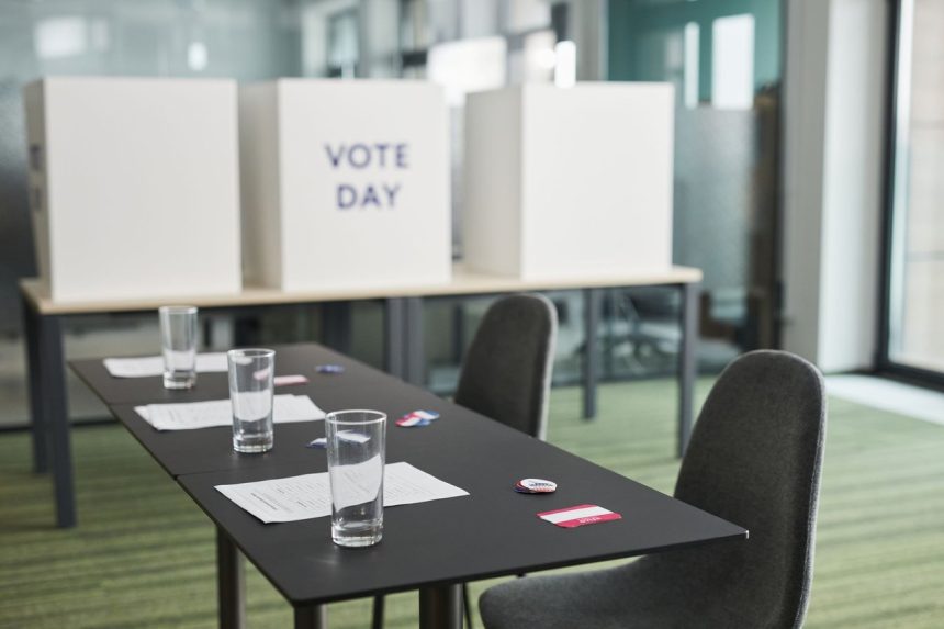Seção eleitoral preparada em uma sala, com mesas, cadeiras e cabines de votação.