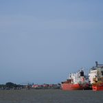 Navios cargueiros atracados em um movimentado porto no Pará, sob céu claro.