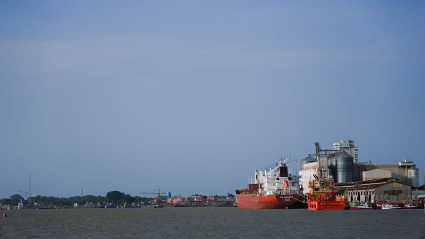 Navios cargueiros atracados em um movimentado porto no Pará, sob céu claro.