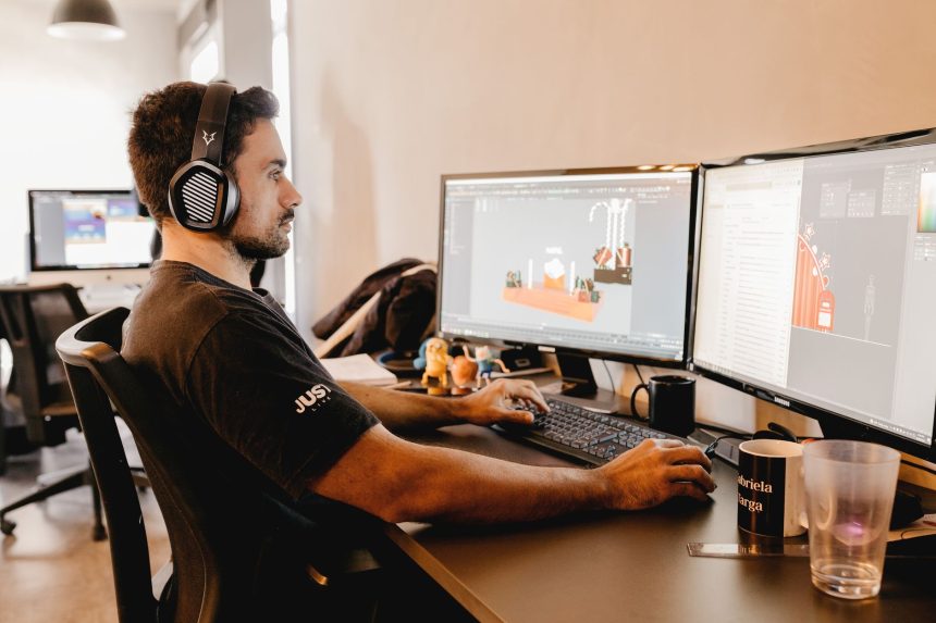 Profissional trabalha em um computador com dois monitores em um escritório moderno.