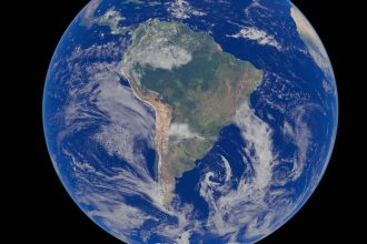 Imagem de satélite da América do Sul vista do espaço, com o continente cercado pelo oceano.